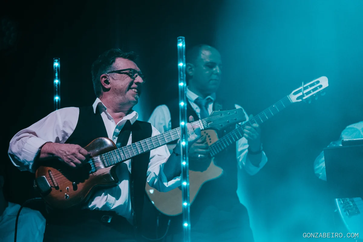 Músicos de la banda tocando bajo una iluminación azul.